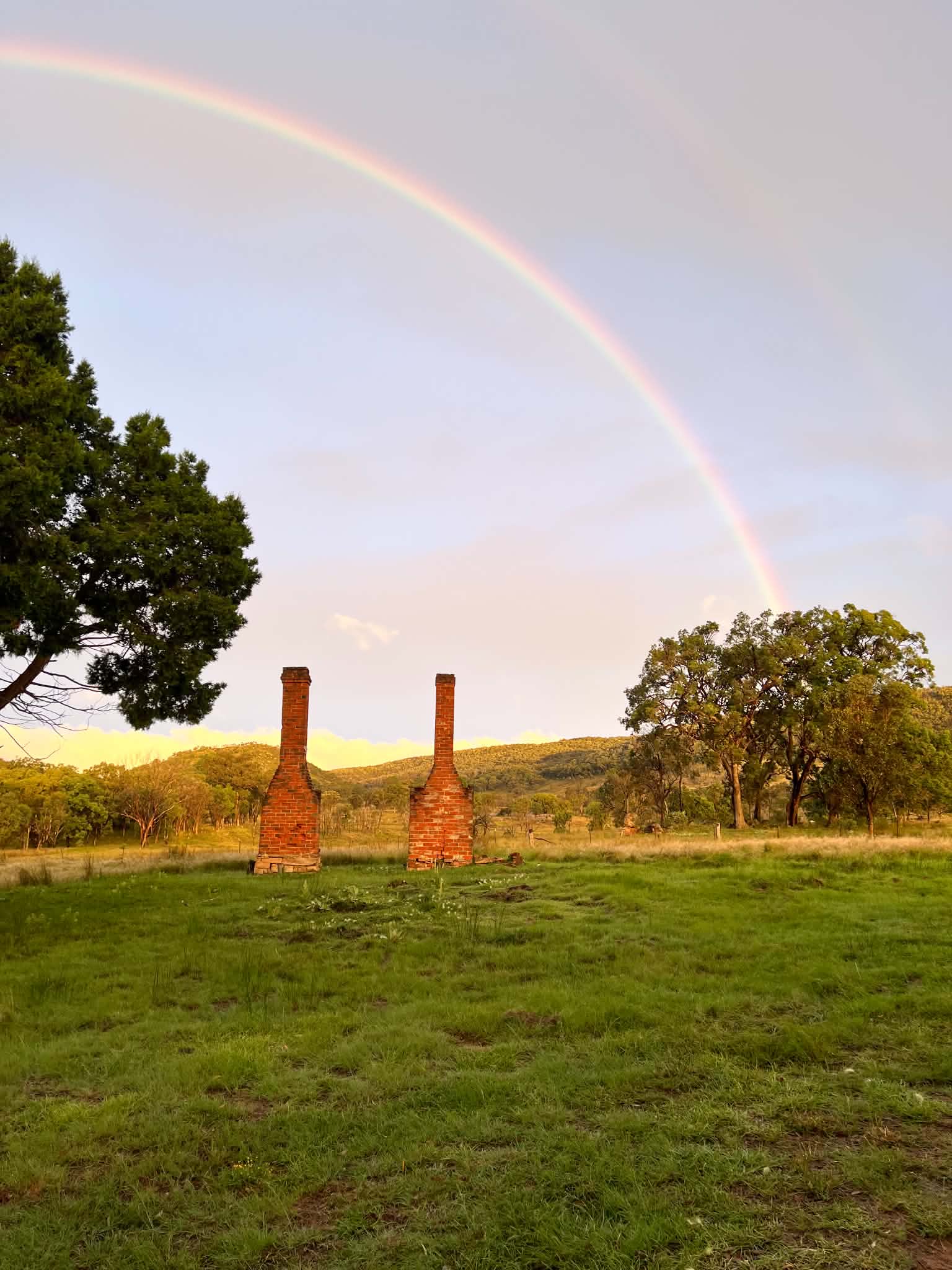 A rainbow arching over the old brick chimneys at Chimney Creek Farm in Woodside, New South Wales